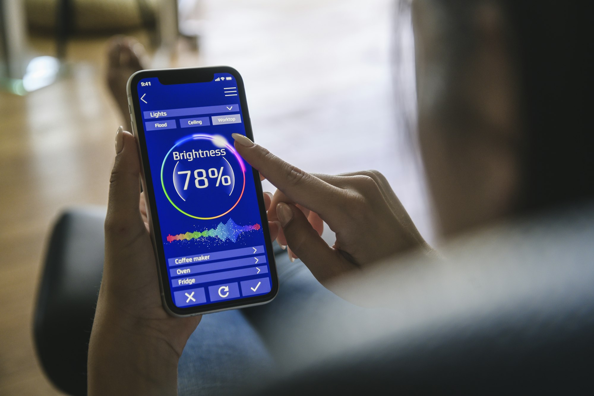 Young woman with smartphone with smart home control functions